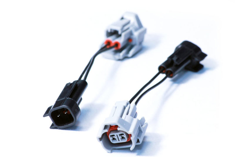 Injector Dynamics Denso to USCAR PnP adapter pair, black and gray connectors with pigtail wires, top angle view