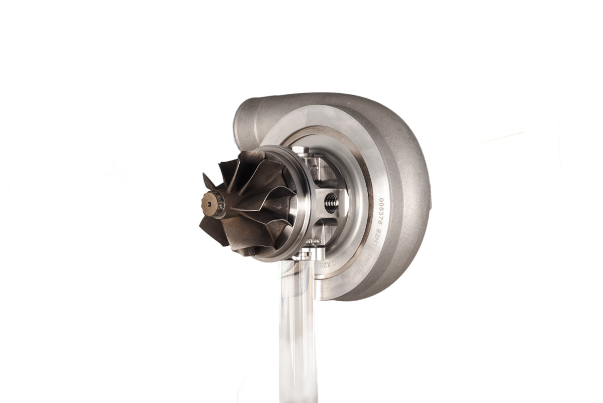 Xona XR 7164S X2C turbo CHRA, front angle showing compressor wheel and clear acrylic mounting stand.