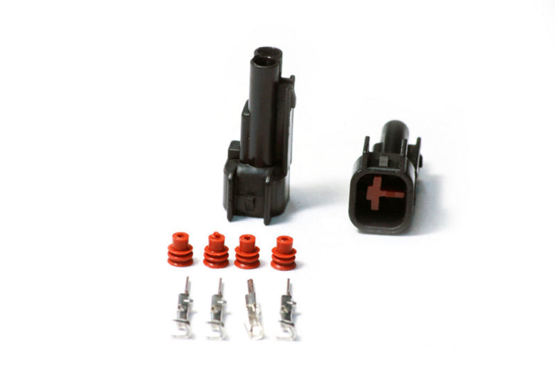 Injector Dynamics USCAR male connector kit, two black housings, four red seals, four pins on white background