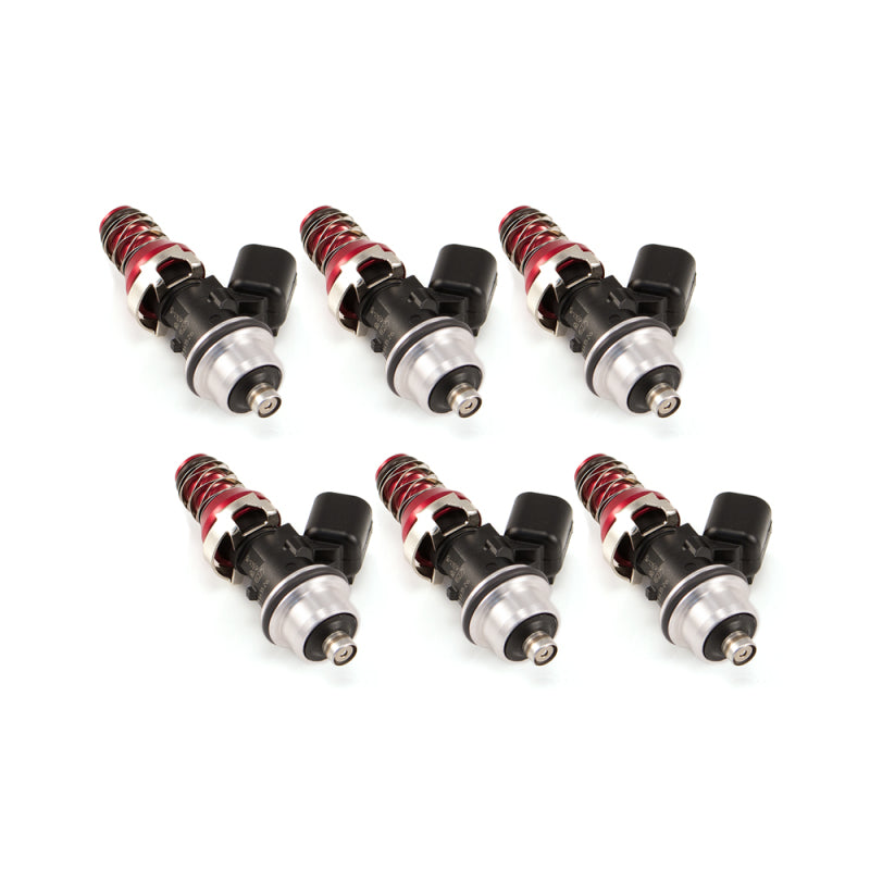 Set of six Injector Dynamics 2600-XDS fuel injectors, angled view showing red springs, black tops, and silver bodies