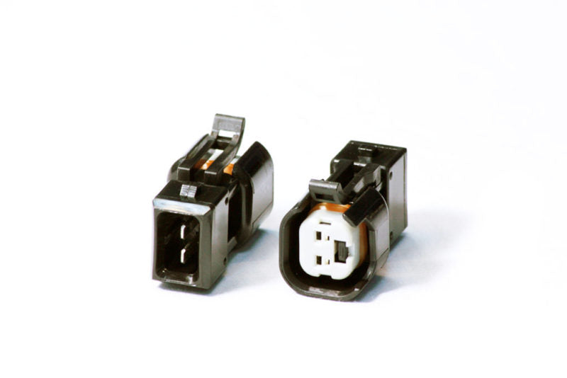 Injector Dynamics USCAR to EV1 PnP adapter pair, black connector housings, front angled view showing pin terminals