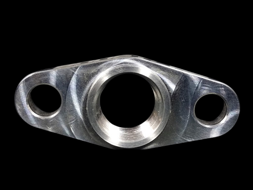 BL Billet T3/T4 turbo oil drain flange, front view showing central bore and two bolt holes, machined aluminum