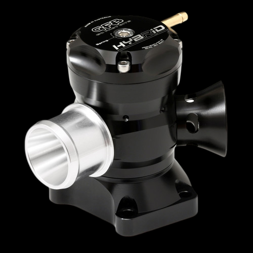 GFB Hybrid TMS Dual Port blow off valve, black anodized body, angled view showing inlet flange, dual outlet ports, and brass fitting on top.